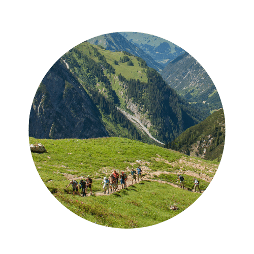 Gruppe Wanderer die auf einem schmalen Weg den Berg hinauf wandern