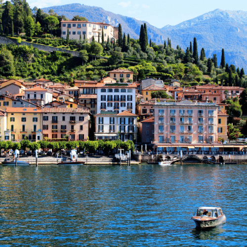 Mediterranes Flair mit bunten, gepflegten Häusern die an der Uferpromenade zum verweilen einladen. Der Blick vom Wasser aus zeigt ein altes Boot.
