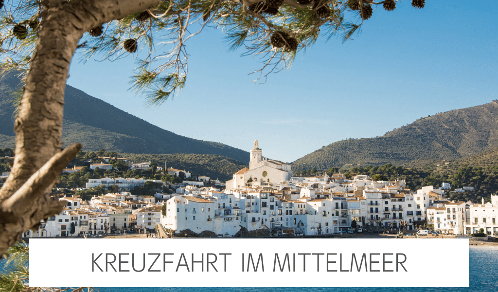 Türkisblaues Meer mündet an Küstenstadt mit vielen weißen Gebäuden. Hinter der Stadt befinden sich bepflanzte Berge. Mittig befindet sich der Schriftzug "Kreuzfahrt im Mittelmeer".